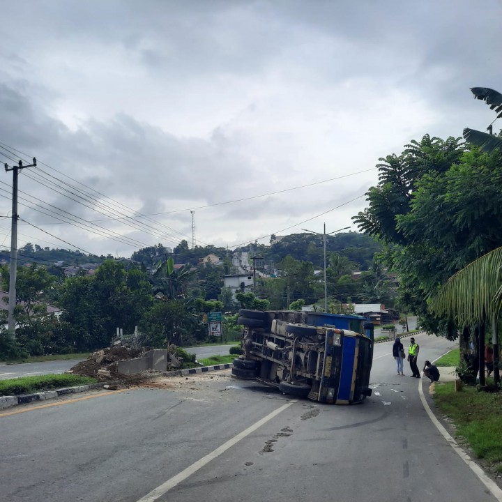 Tak Kuat Menanjak, Truk Hantam Pembatas Jalan lalu Terguling di Kilo 6